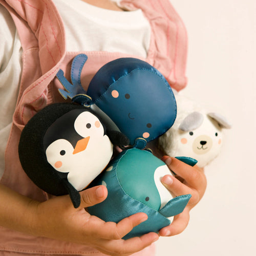 Small child holding a set of 4 soft animal balls in ocean theme