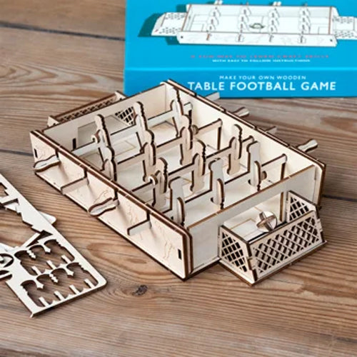 Wooden table football game set with packaging on a wooden surface